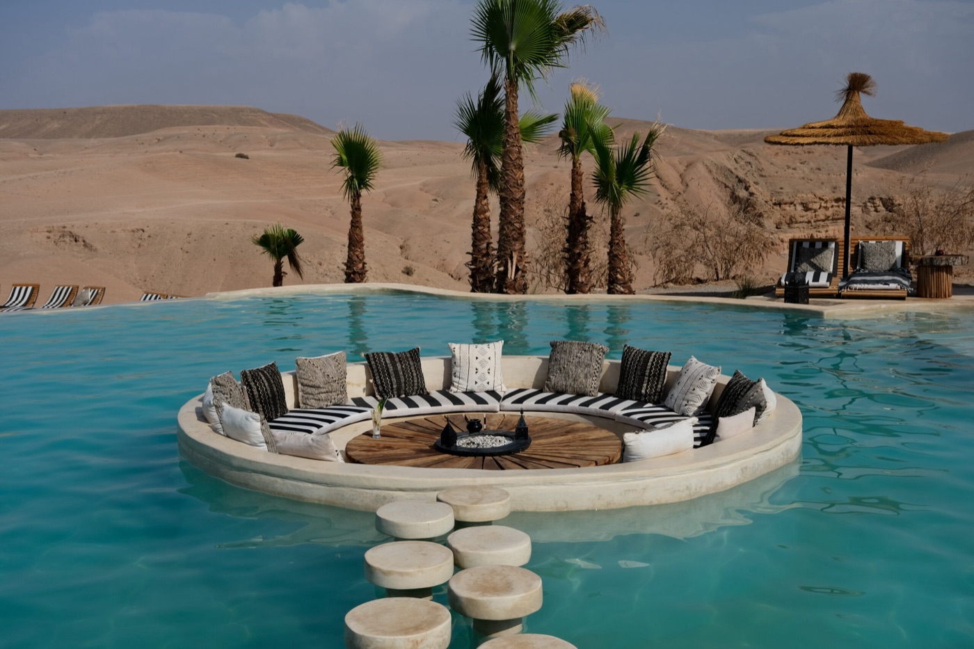 Salon lounge au cœur d'une piscine face au désert d'Agafay